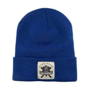 Royal blue fold-up knit beanie featuring a white patch on the front displaying a black & white Teton Valley Skijoring logo